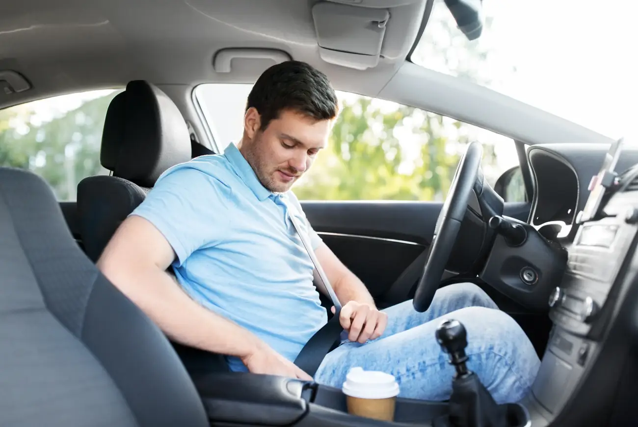 Driver fastening a seat belt at the start of a working day in a fleet vehicle