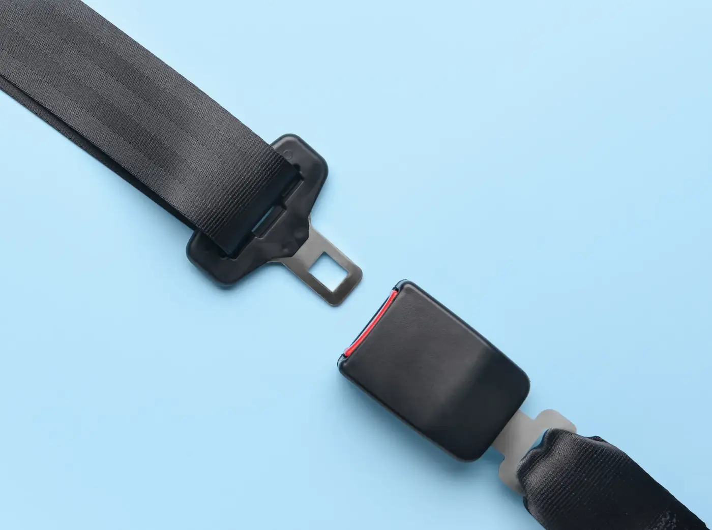 Complete automotive seat belt assembly laid out flat showing webbing, tongue plate and buckle housing