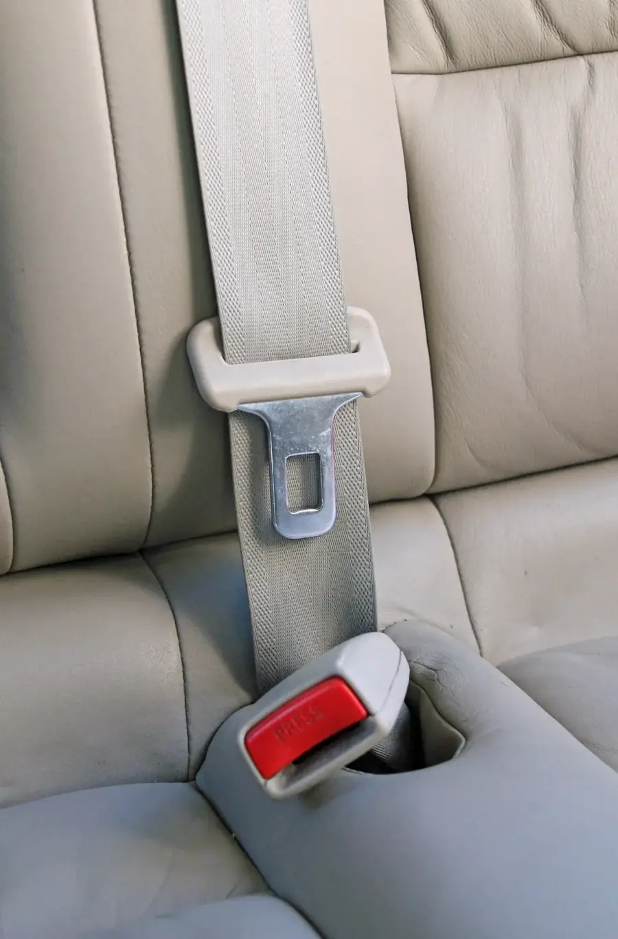 Seat belt webbing running through an upper adjuster loop with the latch plate below